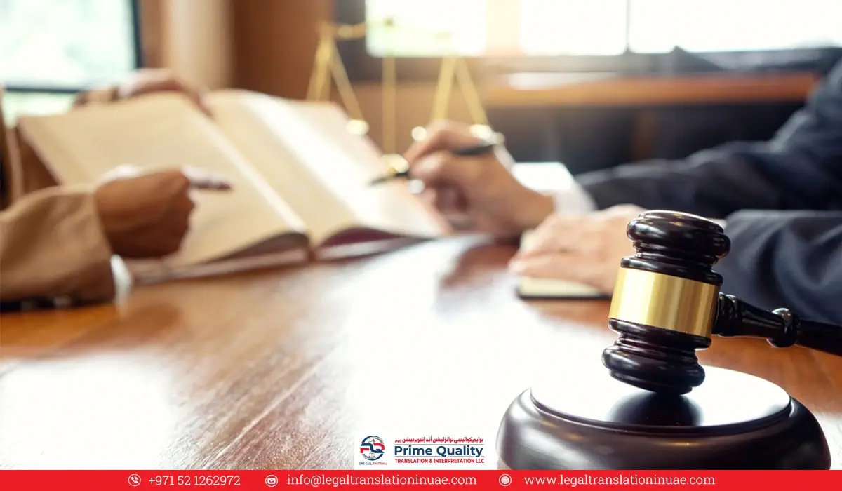 A judge's gavel is in the foreground and two people reviewing documents are in the background.